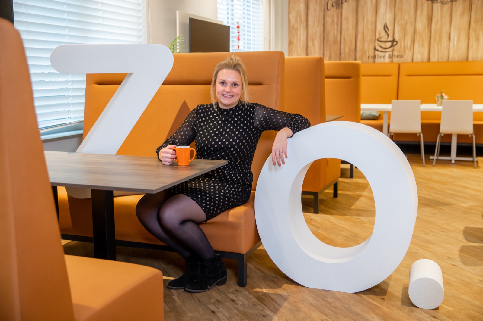 Employee with coffee and the ZO letters in the canteen