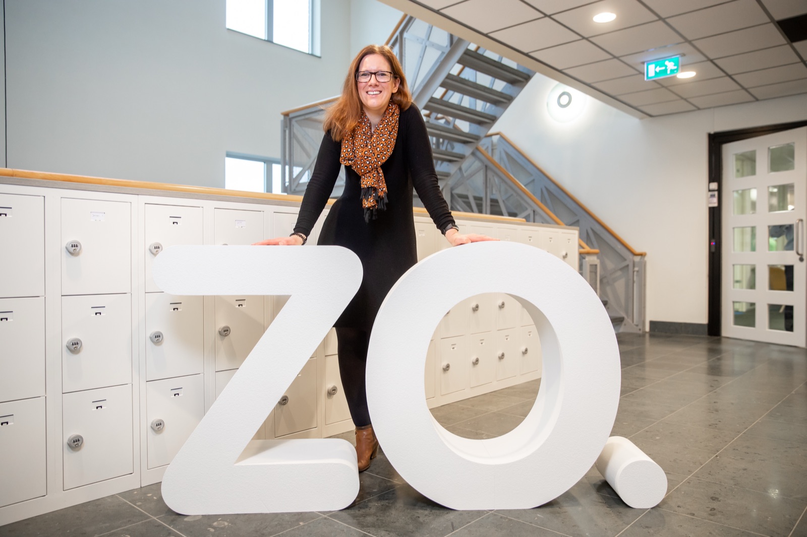 Employee poses with large ZO letters by the lockers